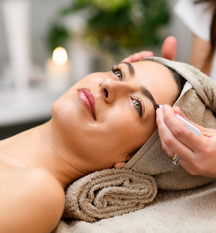 a woman getting eyebrow correction done